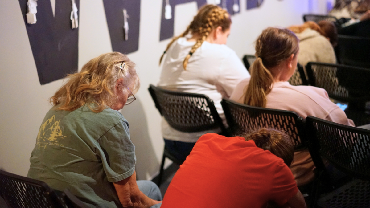 Brenda praying next to a student