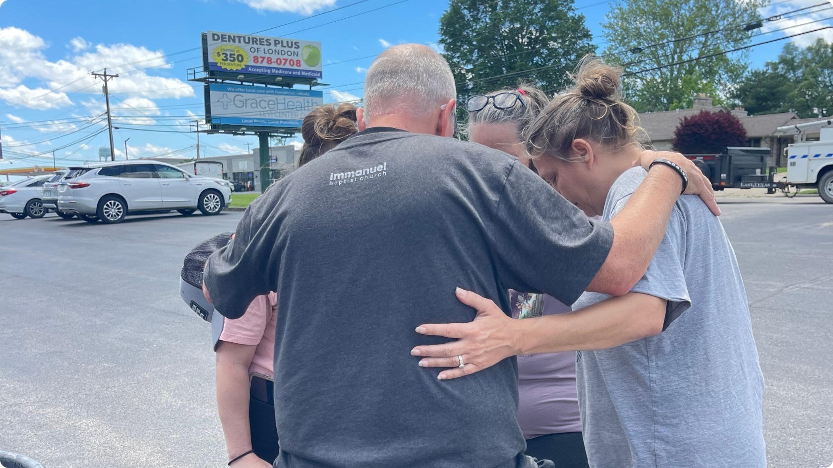 Pastor praying with people after natural disaster