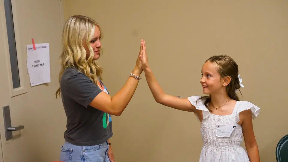 Anna Jo high-fiving a child in her group