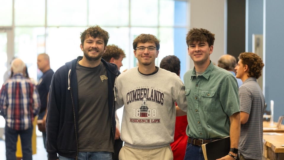 Three men standing side by side at the Immanuel Baptist Church Williamsburg Campus, displaying Christian brotherhood